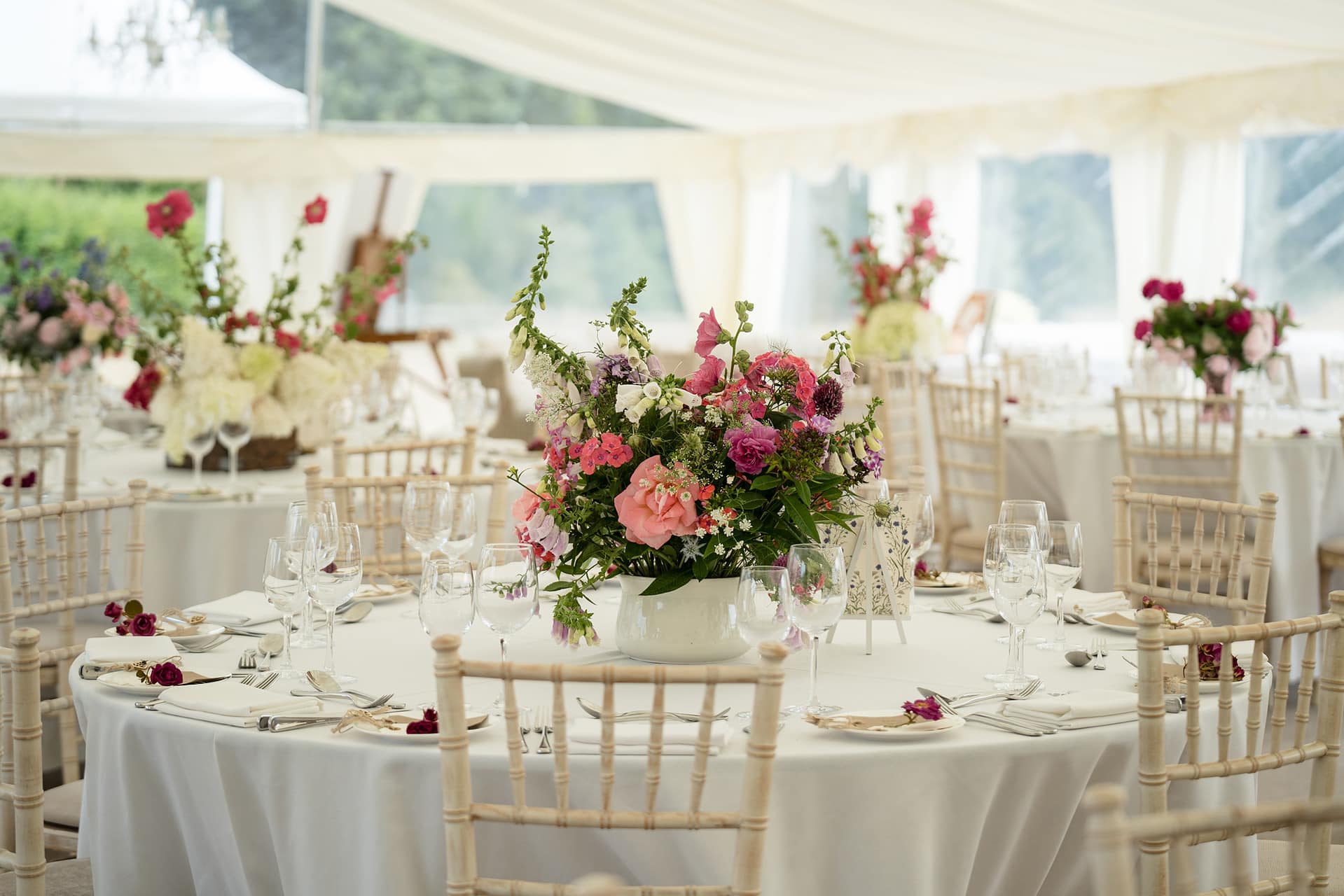 Country style flower table centrepieces for a marquee wedding