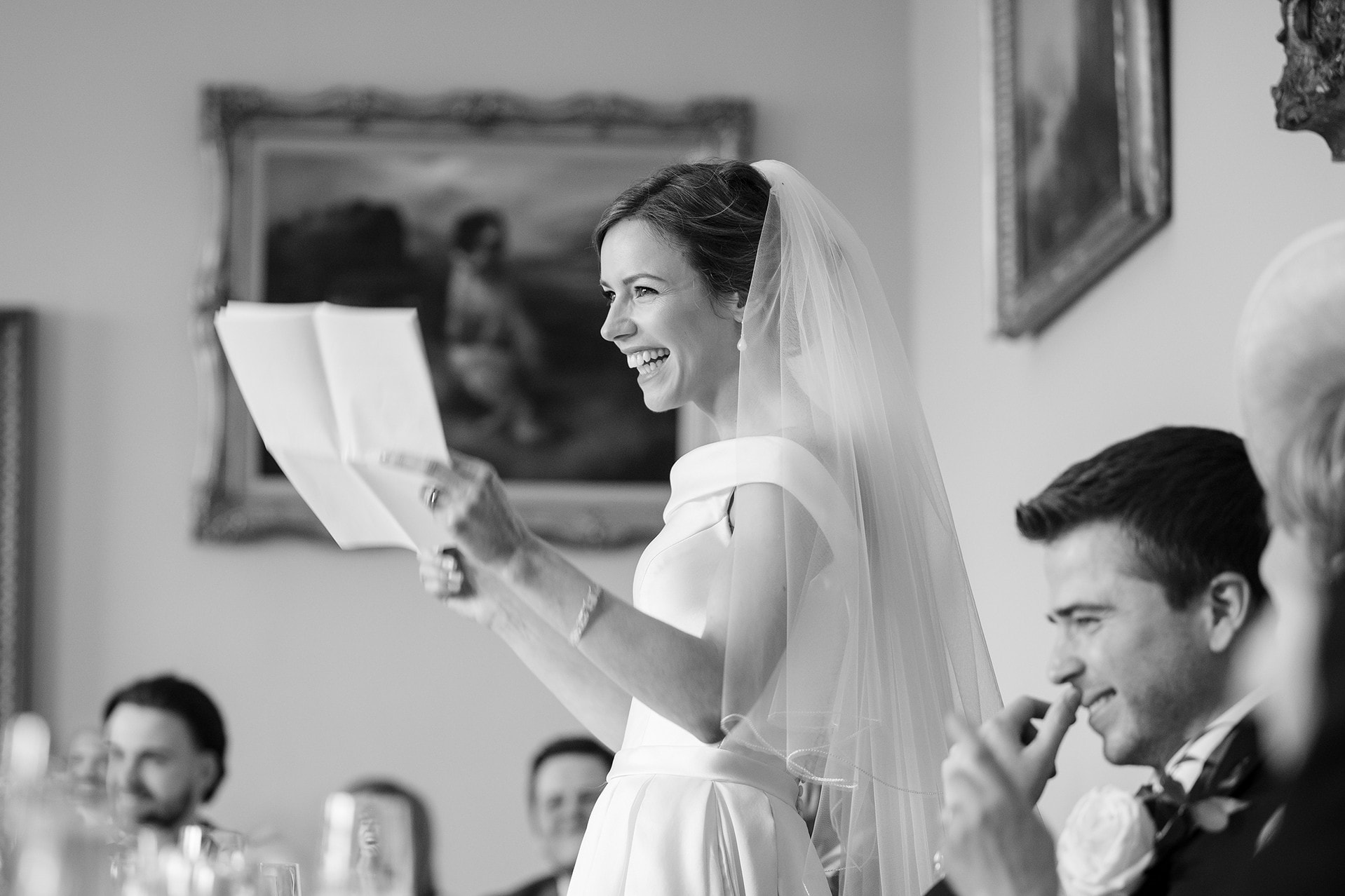 The bride looking up and laughing as she makes her wedding speech