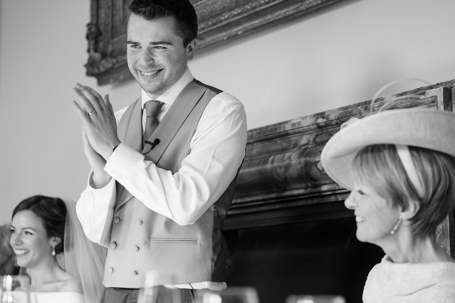 The groom clapping to thank someone during his speech