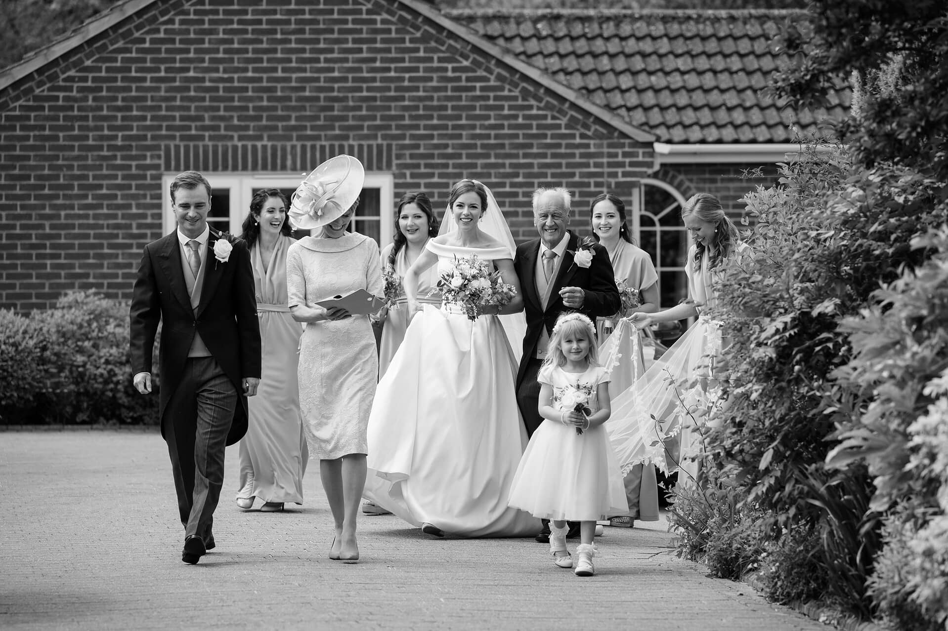 The bride, her parents, brother, and bridesmaids leaving the house to walk to church