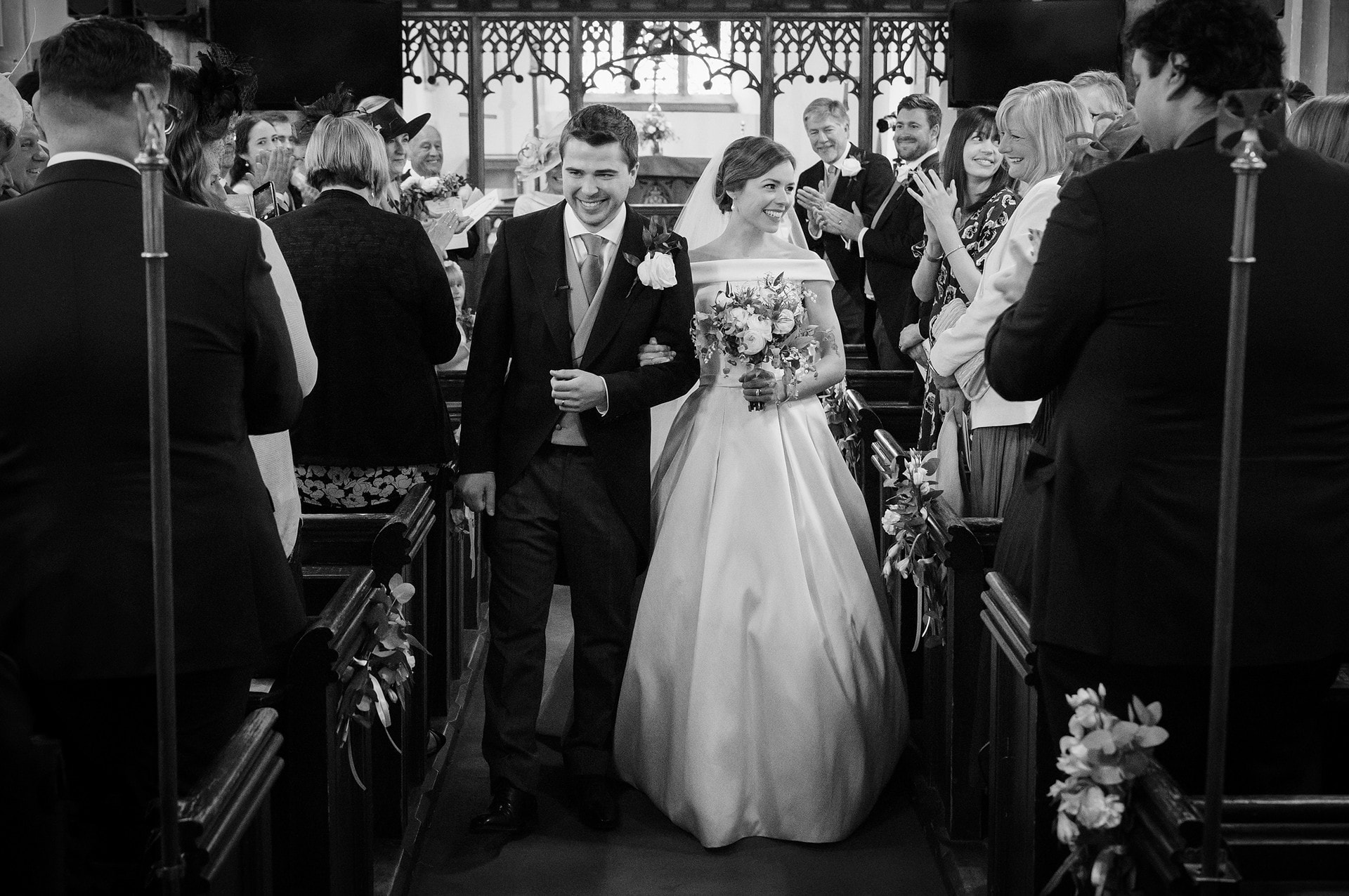 Bride and groom walking down the aisle at St Catherine's church in Houghton on the Hill