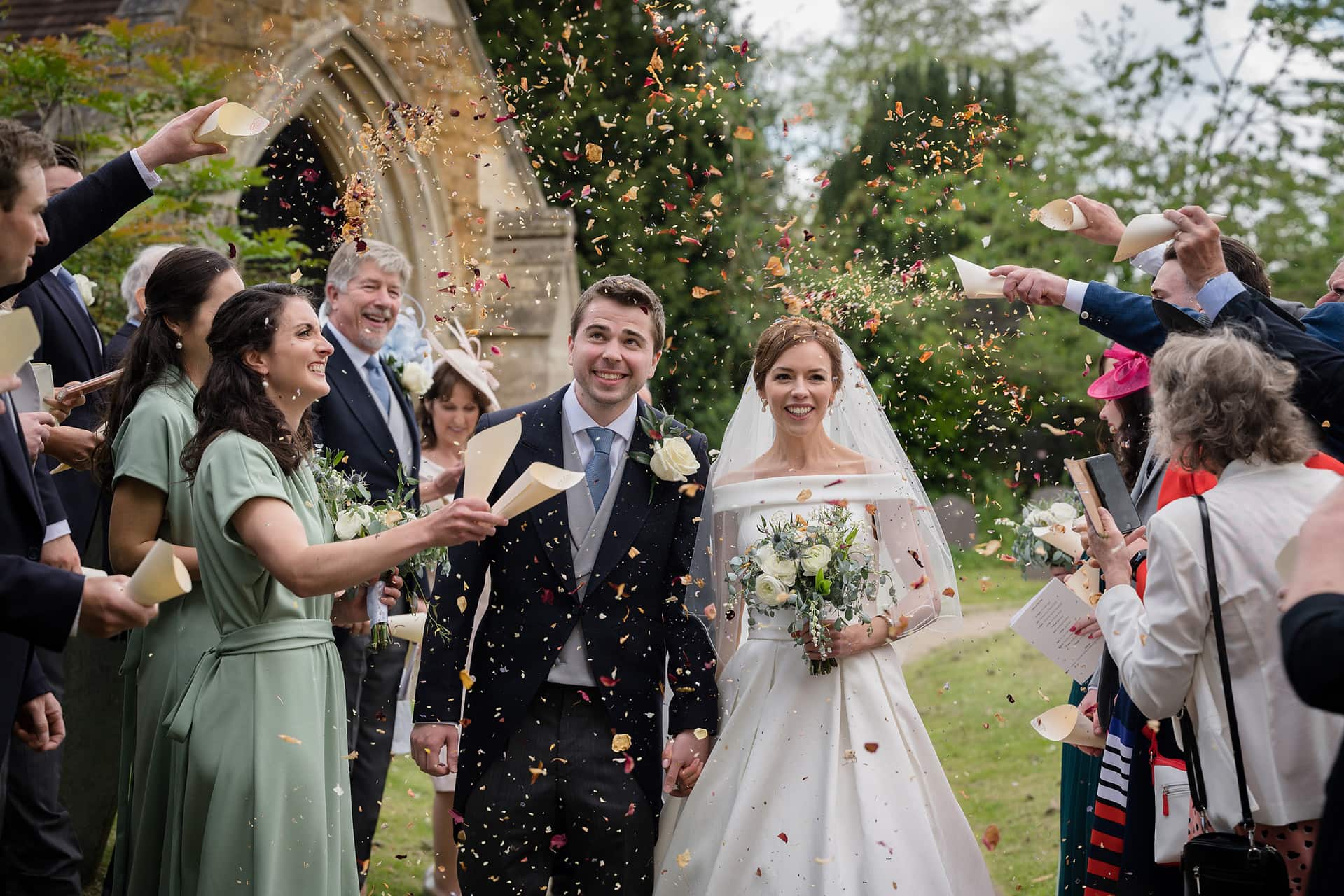 Confetti being thrown over the bride and groom at St Catherine's church in Houghton on the Hill