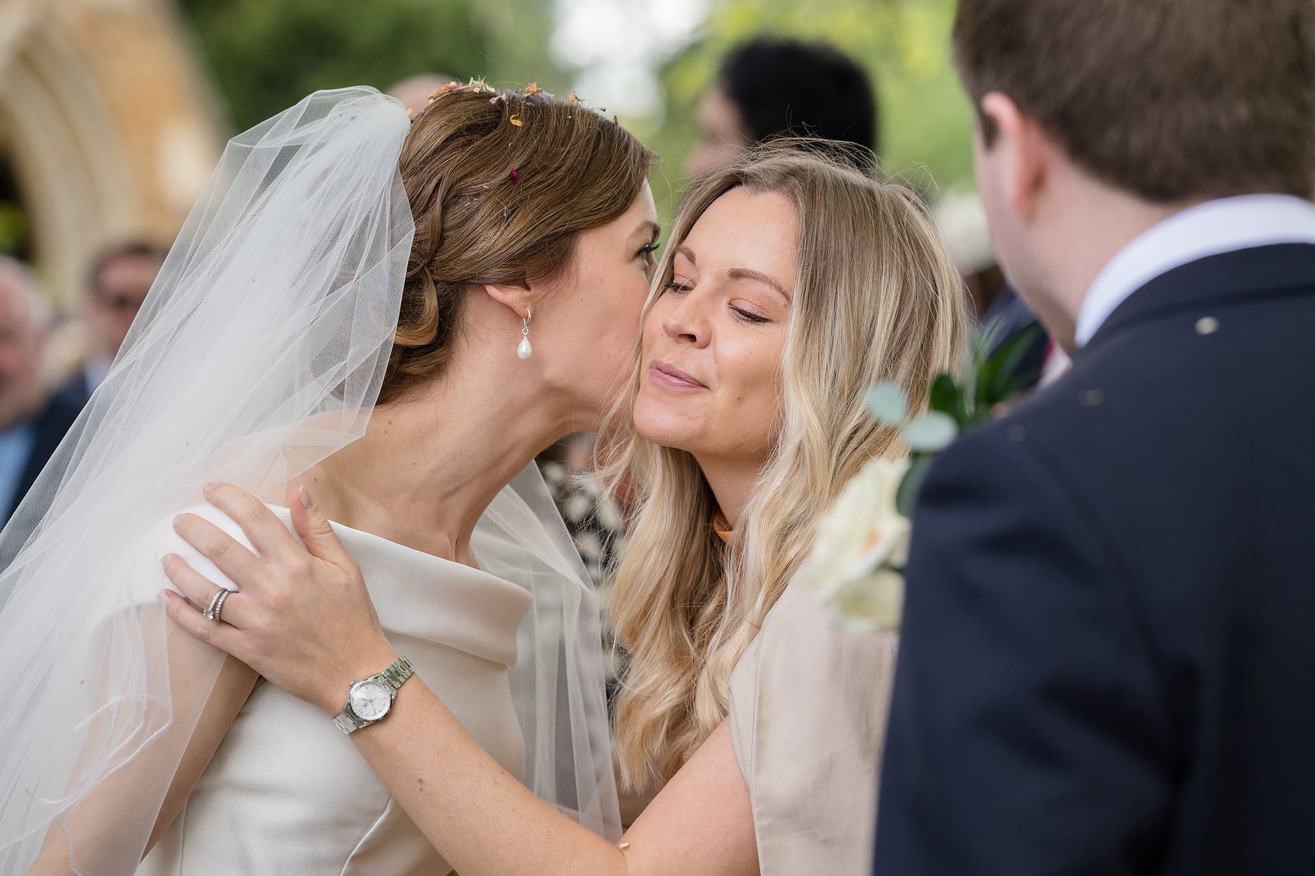 A wedding guest kissing the bride in congratulations