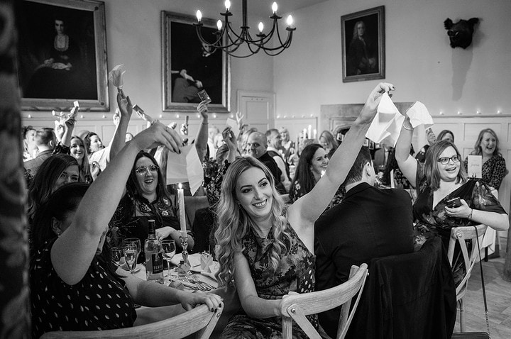 Wedding guests waving tissues in the air as a joke for the bride who often cries