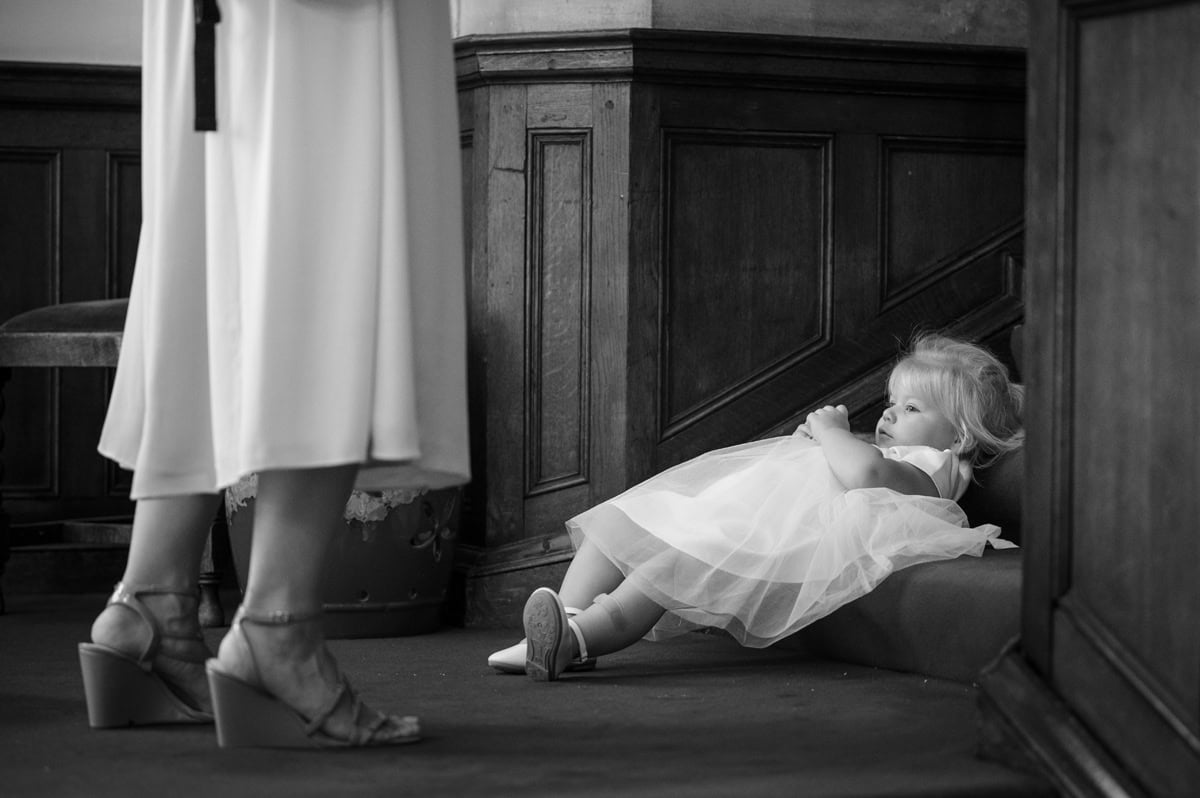 Young flower girl lying down on carpeted stairs