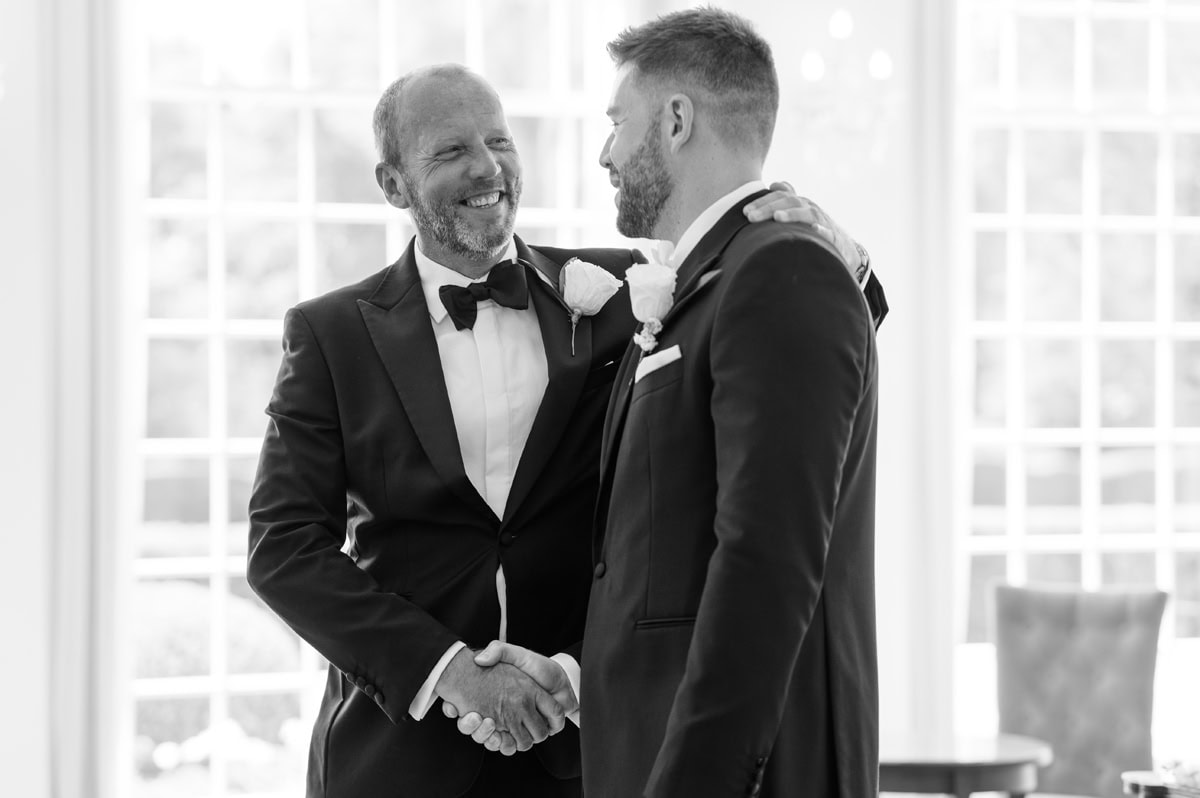 Man shaking groom's hand before wedding ceremony starts