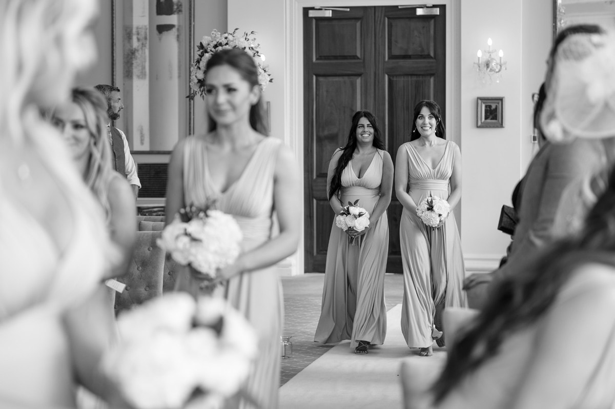 Bridesmaids walking down the aisle in grand setting