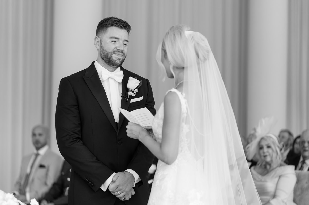 Groom looking lovingly at bride as she makes her marriage vows