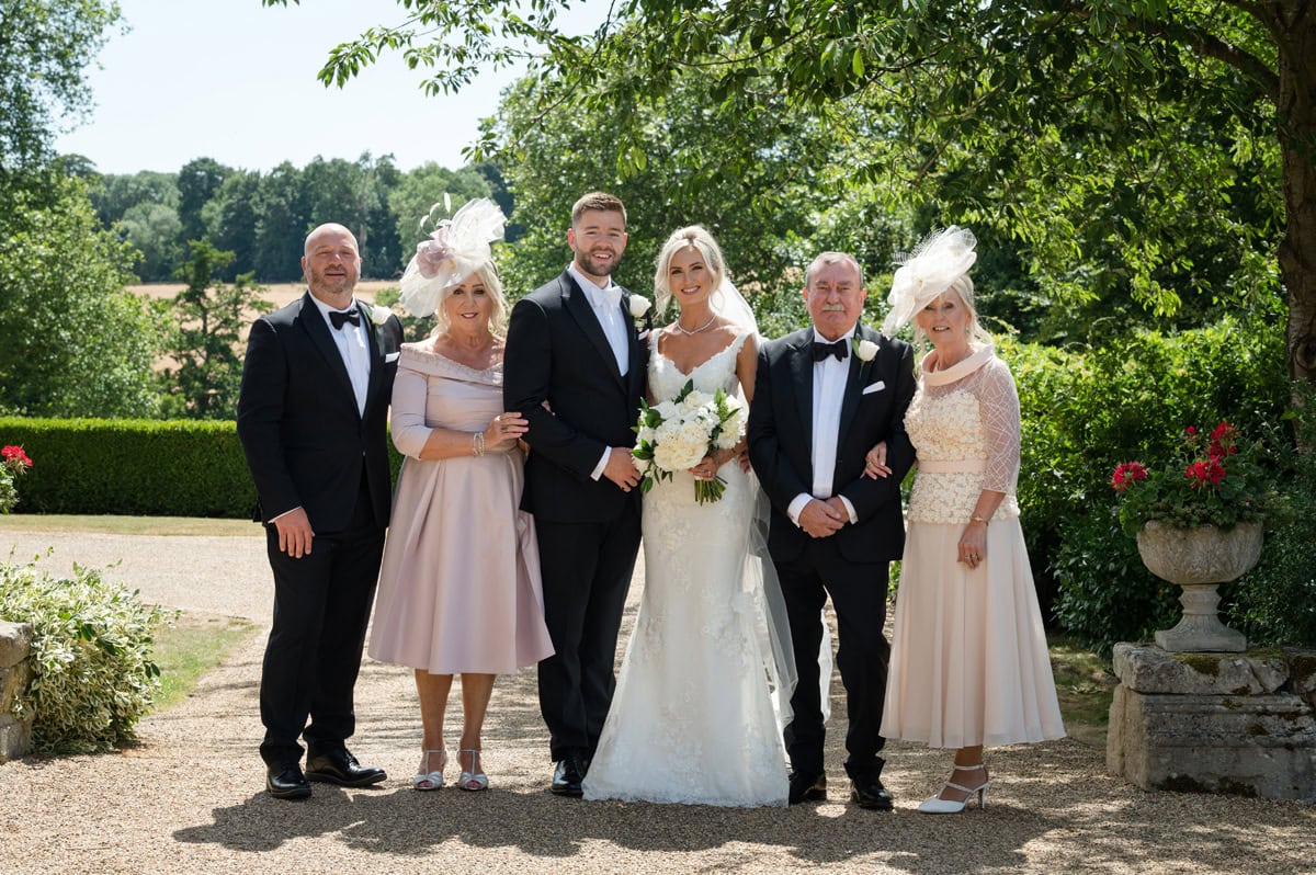 Traditional family photo at a wedding taken in a mature country house garden