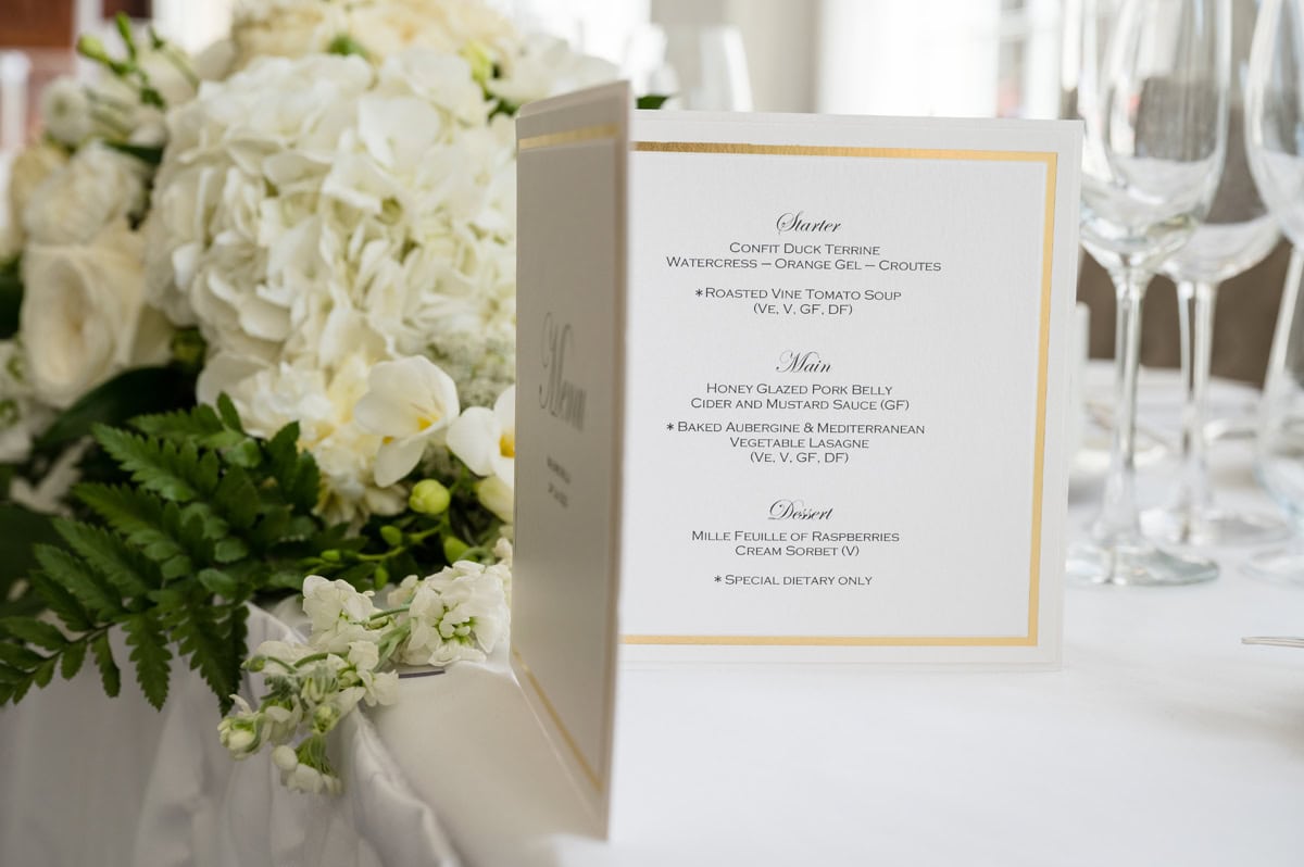 Wedding breakfast menu on white card with gold foil border