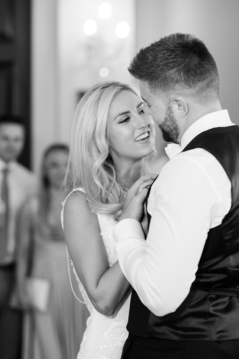Bride looking lovingly at the groom as they sing along to the music during their first dance