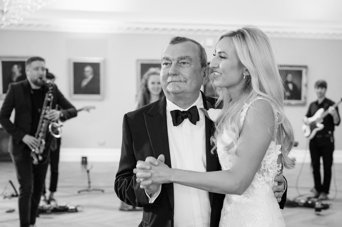 Bride and her father dancing together at a wedding with a live band