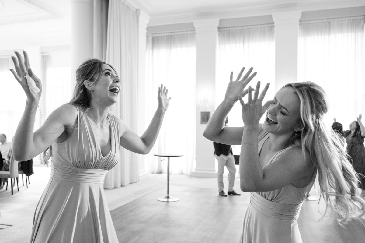 Two bridesmaids dancing wildly on a dancefloor at a wedding