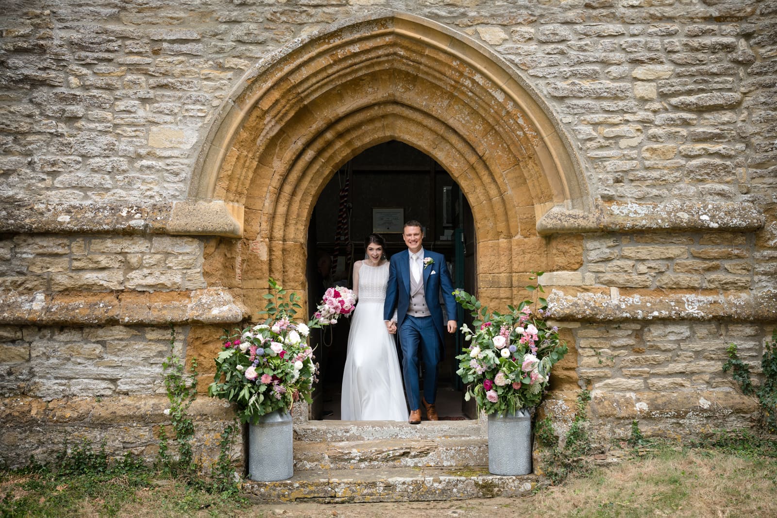 Bride and groom walking out of church door after ceremony
